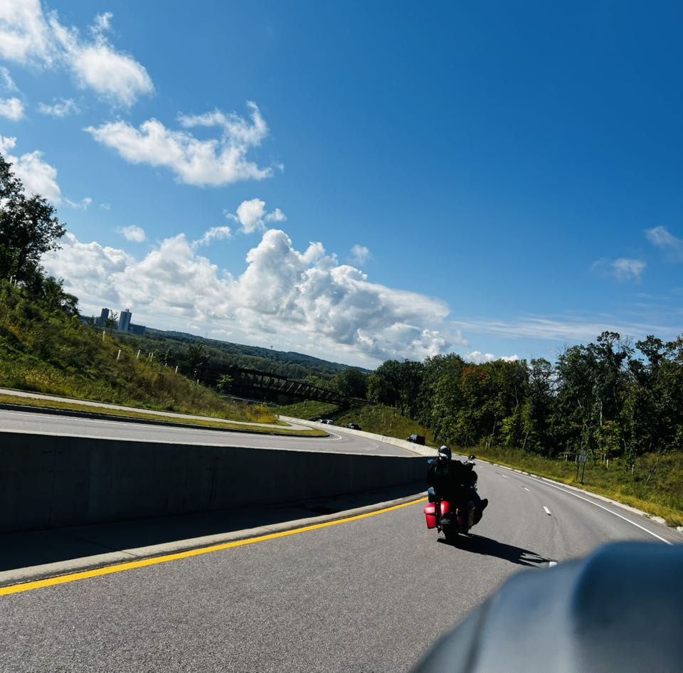 Riding a highway curve on a sunny day, seen from a chapter member's bike